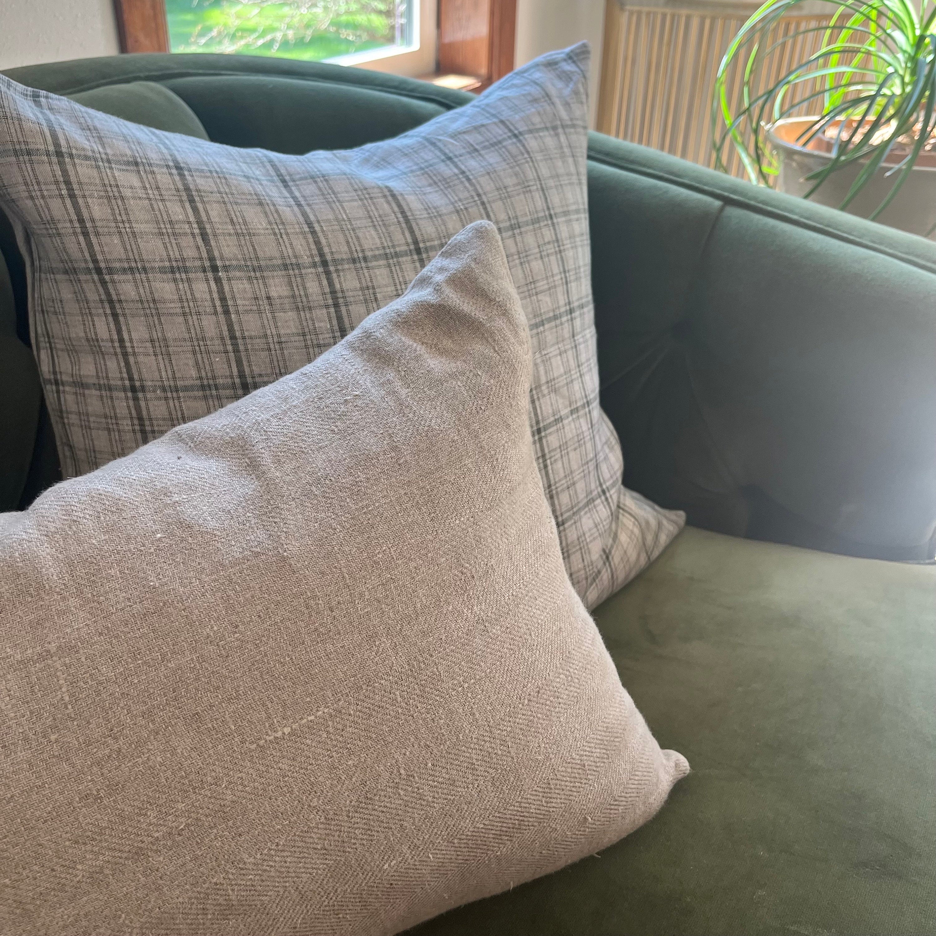 Striped linen pillow cover in soft pink, white, and tan displayed on a cozy neutral-toned sofa. The handcrafted texture and soothing colors enhance a warm, inviting living space, perfect for modern, boho, or coastal-style décor.